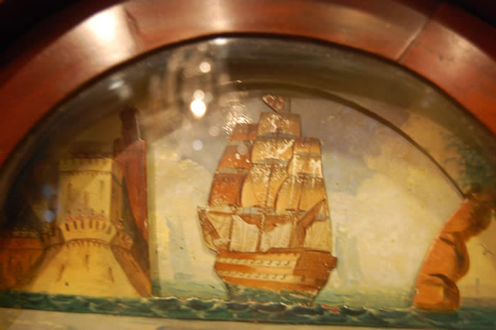 This is very decorative 'Rocking Ship' Longcase clock of 8day duration with a pleasant bell strike for the hour . This clock has in the arch of the dial a Ship that Rocks from side to side with each tick of the clock , this feature was popular when the clock was made as there were no moving images elsewhere to be seen .The dial also includes a calendar and seconds hand with all hands being the original Brass fret cut and punch decorated . The cabinet is of highly figured mahogany with box-line inlays , turned columns to both the hood and to the trunk . Standing on small bracket feet . David Bevan of Hirwain is listed in the Slaters Commercial directory of 1858 , this clock dates to around the 1840-50's . 